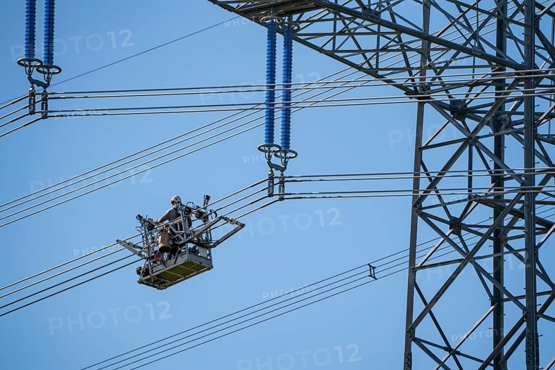 Construction of a new line route, 380 KV extra-high-voltage line between Osterath and Gohr, near Neuss, fitters in line trolleys, on the conductor cables, installing field spacers at great heights, North Rhine-Westphalia, Germany, Europe