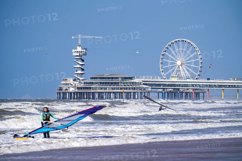 The pier and Ferris wheel at Scheveningen beach, strong swell, windsurfers, Netherlands