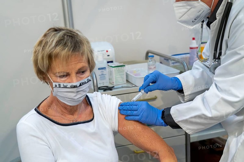 Vaccinator administers a vaccination, during the test run in the vaccination centre for corona vaccinations, in a hall at Messe Essen, by the city, the fire brigade and various aid organisations, 12 vaccination lines for a daily vaccination of up to 2400 people, operated by the North Rhine-Westphalia Association of Statutory Health Insurance Physicians