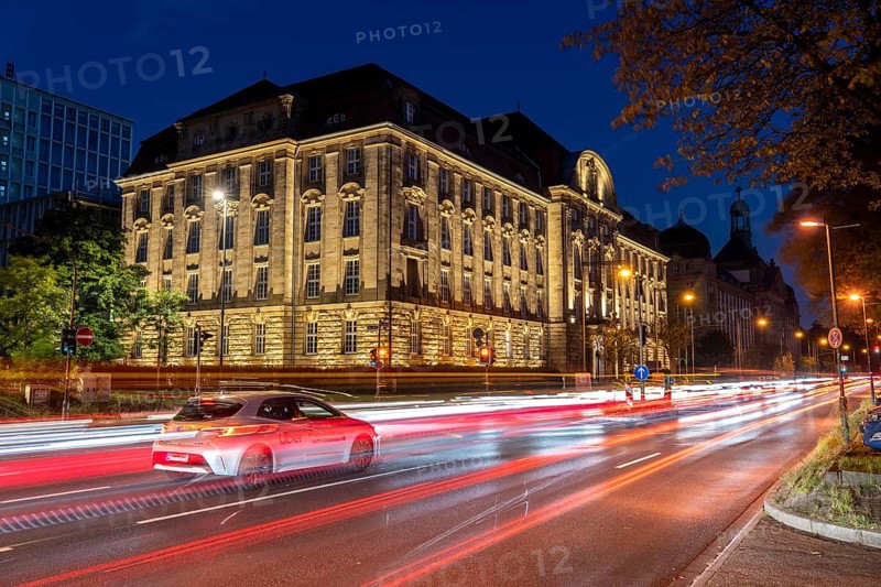 Evening city centre traffic, Cecilienallee, federal highway B1, rental car, taxi, which is mediated to passengers by the online mediation service Uber via an app, waiting on a left turn lane for the onward journey, building of the Düsseldorf Higher Regional Court