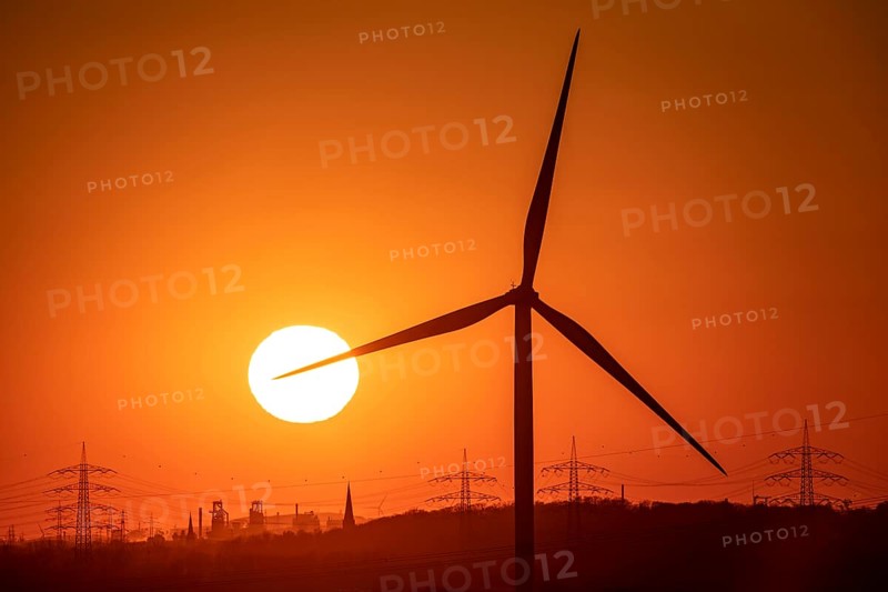 Wind turbine of the Emschergenossenschaft, view to the west, in Essen, sunset, behind the blast furnaces 8 and 9 of Thyssenkrupp Steel, in Duisburg, North Rhine-Westphalia, Germany, Europe