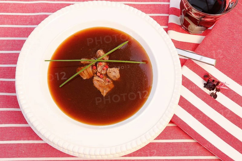 Southern German cuisine, oxtail soup with red pepper in a soup plate, bound soup, meat soup, chives, soup plate, traditional cuisine, speciality, food photography, studio, Germany, Europe