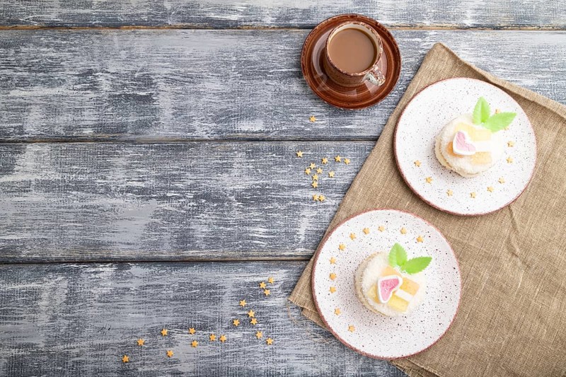 Decorated cake with milk and coconut cream with cup of coffee on a gray wooden background and linen textile. top view, flat lay, copy space