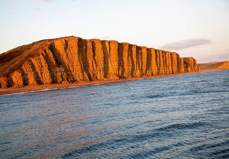 Golden afternoon light on sandstone cliffs, East Cliffs, West Bay, Bridport, Dorset, England, UK