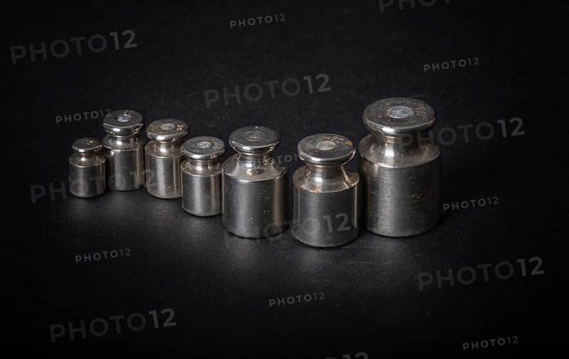 A set of small metal weights on a gray background