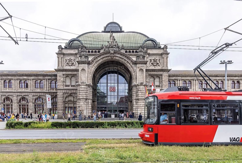 Nuremberg Central Station, exterior view of the building with the logo of Deutsche Bahn AG, tram of VAG Verkehrs-Aktiengesellschaft Nürnberg. Nuremberg, Bavaria, Germany, Europe