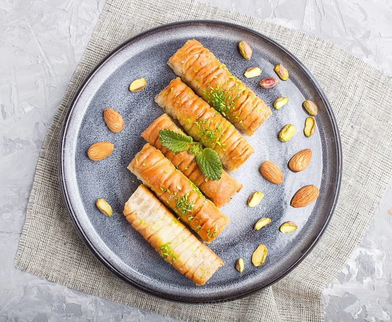 Baklava, traditional arabic sweets in gray ceramic plate on a gray concrete background. top view, close up