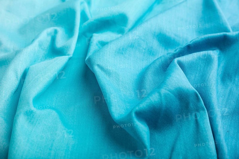 Fragment of cotton blue tissue. Side view, natural textile background and texture. wave concept, abstract