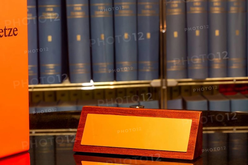 Brass sign with space for text in front of a large bookshelf