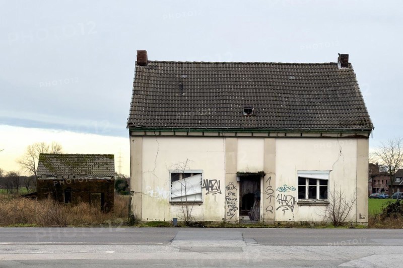 Abandoned house junk property on country road, on house wall graffiti by sprayer hate message against police Fuck the Police and digits code 1312 for All Cops are Bastards, Germany, Europe