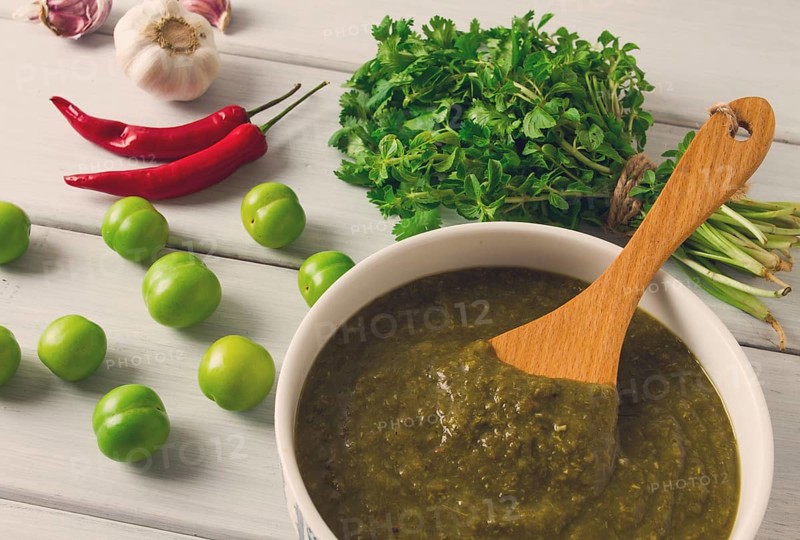Tkemali sauce, traditional Georgian cuisine, green cherry plum, with ingredients for sauce, cilantro, mint, hot pepper, garlic, on a white wooden table, close-up, rustic, food background, no people, selective focus, sauce, green sauce, tkemali, georgian cuisine, homemade