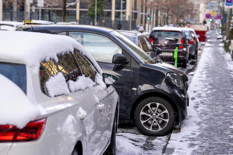 Winter in the city, small Smart car has used a tiny parking space to park sideways, in the city centre of Frankfurt, Hesse, Germany, Europe