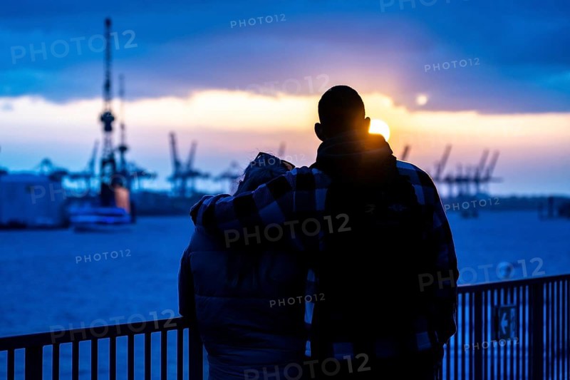 Port of Hamburg, couple looking at the Blohm + Voss shipyard, evening, cranes of the container terminals, sunset, Hamburg Germany