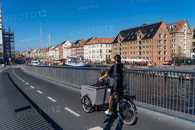 Cyclists on the Inderhavnsbroen cycle and footpath bridge, over the harbour, at Nyhavn, Copenhagen is considered the cycling capital of the world, 45 % of the population travel by bike, Denmark, Europe