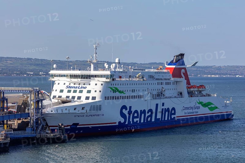 Large ferry with colourful design docked in harbour surrounded by calm waters, Belfast