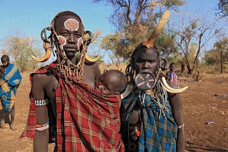 South Ethiopia, in Maco National Park, Mursi tribe, Mursi woman with baby, painted skin and headdress, young plate lip woman, plate in lip, body jewellery, Ethiopia, Africa