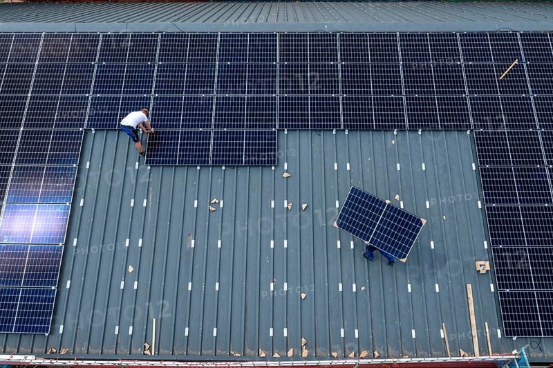 Installation of solar modules on the roof of a barn on a farm, over 210 photovoltaic modules are installed on the roof, North Rhine-Westphalia, Germany, Europe