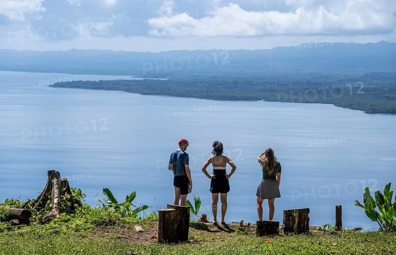Three tourists look out over the South Pacific and rainforest, Osa Peninsula, Punterenas Province, Costa Rica, Central America