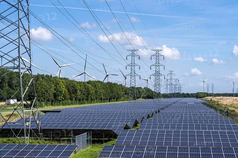 High-voltage power line route, the space underneath is used for a solar park over 5 km long, behind it a wind farm, in the harbour area of Vlissingen-Oost, Netherlands