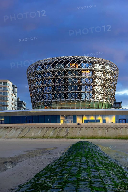 SILT casino, hotel and restaurant in seaside resort Middelkerke seen from beach along the North Sea coast illuminated at dusk, West Flanders, Belgium, Europe