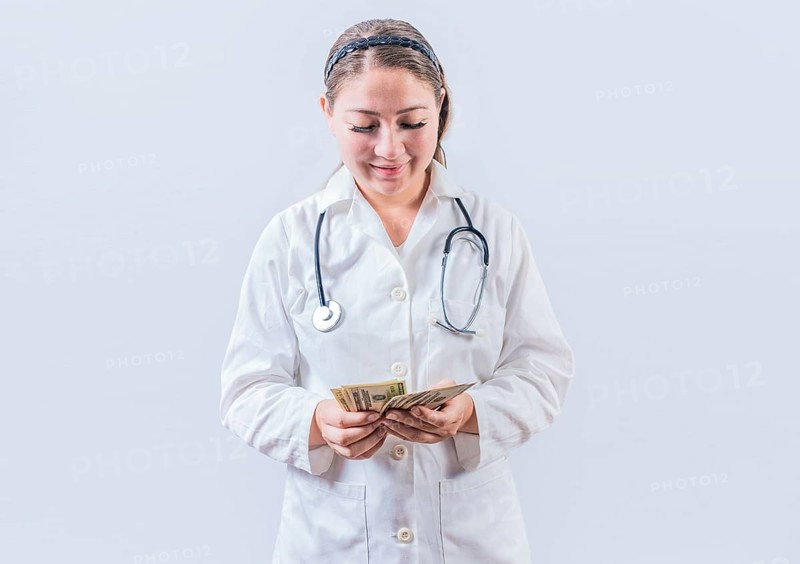 Corrupt female doctor counting money isolated. Female doctor counting banknotes on white background. Medical corruption concept