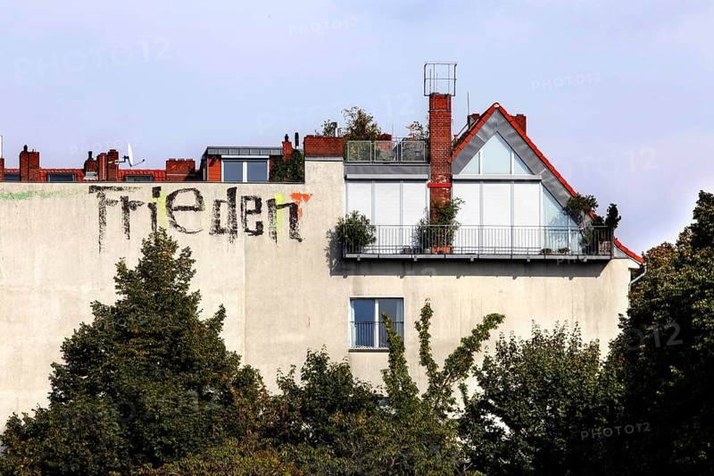 Peace is written in large letters on the wall of a house. Peace is defined as a wholesome state of calm, the absence of disturbance and war, Berlin, 05.09.2022