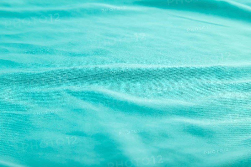 Fragment of smooth silk blue tissue. Side view, natural textile background and texture