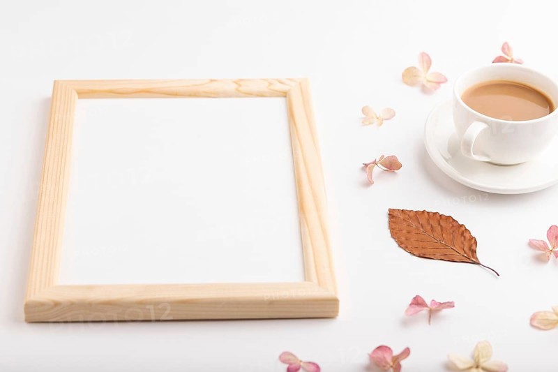 Composition with wooden frame, brown beech autumn leaves, hydrangea flowers and cup of coffee. mockup on white background. Blank, side view, still life, copy space