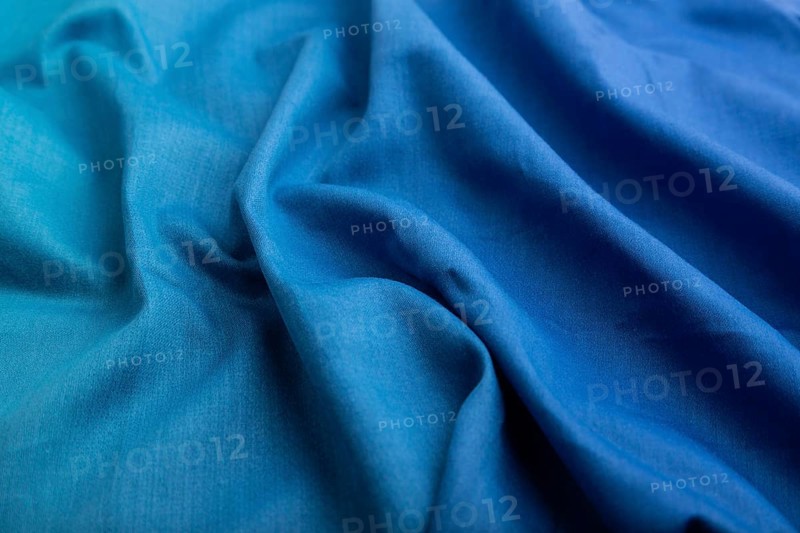 Fragment of cotton blue tissue. Side view, natural textile background and texture. wave concept, abstract