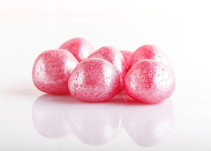 Heap of pink hard sugar candies isolated on white background
