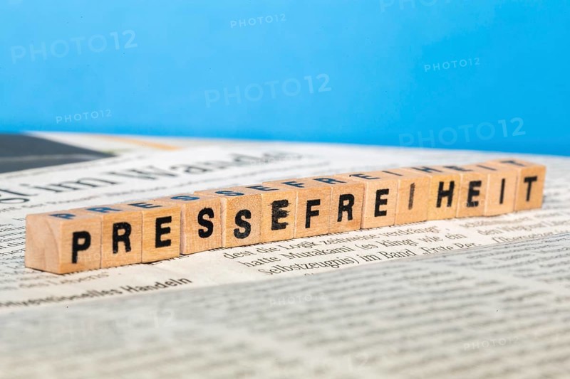 Symbolic image of press freedom: letter cube on a newspaper