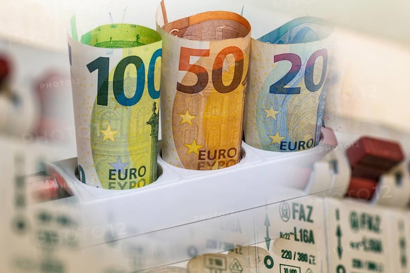 Symbolic image of electricity costs: euro banknotes in a multiple socket and a distribution box
