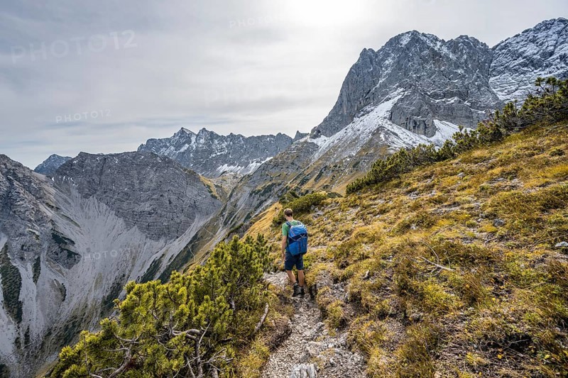 Mountaineers on a hiking trail on the ridge of Hahnkampl, mountain panorama with rocky steep peaks, view of summit Lamsenspitze, in autumn, Karwendel Mountains, Alpenpark Karwendel, Tyrol, Austria, Europe