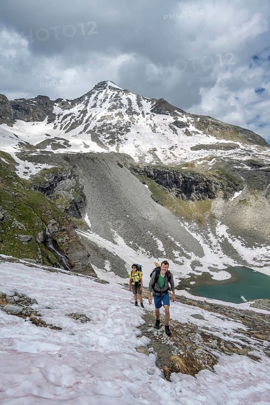Two mountaineers on a hiking trail with snow, mountain landscape with summit Hoher Riffler and Friesenbergsee, Zillertal Alps, Tyrol, Austria, Europe