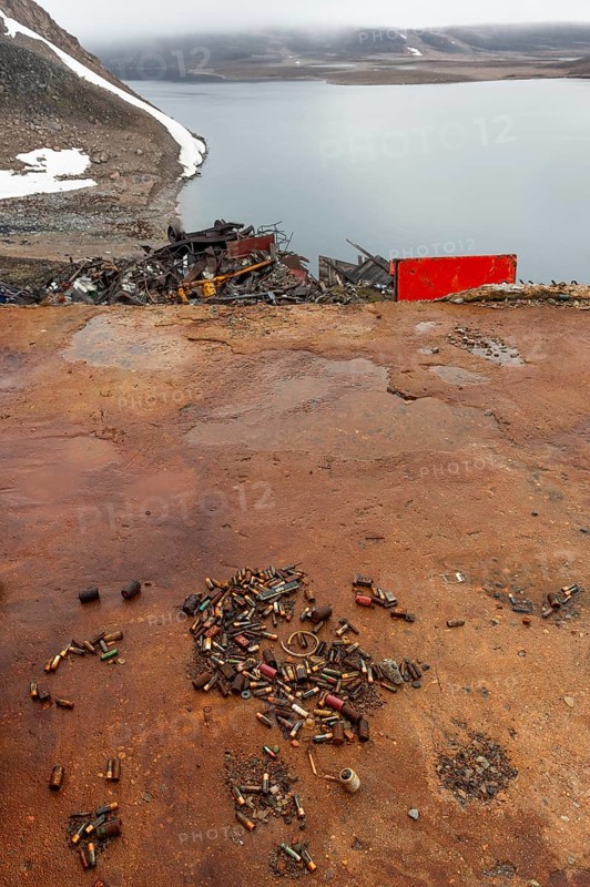 Rusted bullet casings, leaking rusty batteries and scrap metal, arctic settlement Ittoqqortoormiit, Scoresbysund or Scoresby Sund or Greenlandic Kangertittivaq, East Greenland, Greenland, North America