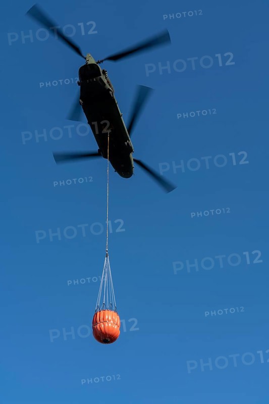 Forest fire in the German-Dutch border region near Niederkrüchten-Elmpt, in a nature reserve, use of fire-fighting helicopters, Boeing CH-47 Chinook helicopter, of the Dutch Air Force with extinguishing water tank, Bambi Bucket max