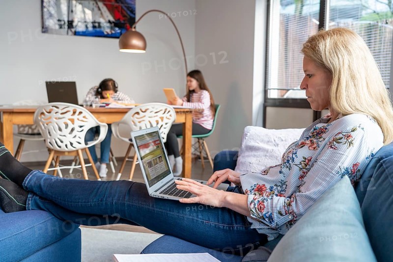 Homeschooling, during the lockdown in January 2021, children learning at home for school, a girl in video lessons with her class, her mother is in the home office and works on her laptop with video chat, school closures, distance learning, effects of the corona crisis in Germany