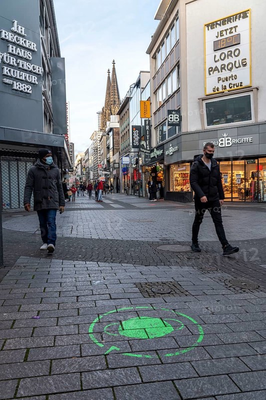 First day of the Christmas lockdown in the Corona crisis, empty shopping street, closed shops, hardly any passers-by, logo on the floor, notice about the obligation to wear masks, Hohe Straße, in Cologne, North Rhine-Westphalia, Germany, Europe