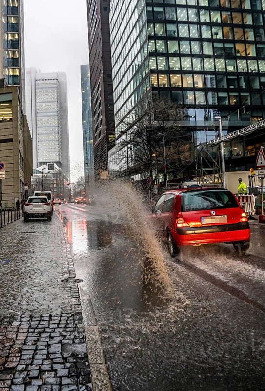 Winter, rainy weather, freezing rain, large puddle, puddle of water, in the city centre, Große Gallusstraße, vehicles driving through, spraying water fountains, Frankfurt am Main, Hesse, Germany, Europe