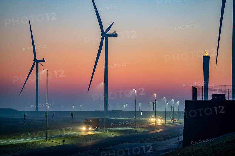 Lorry on the road to Euromax Terminal Rotterdam, ENECO wind farm on the dike around the port of Maasvlakte 2, 22 wind turbines with a capacity of 116 megawatts, sunset, Rotterdam, Netherlands