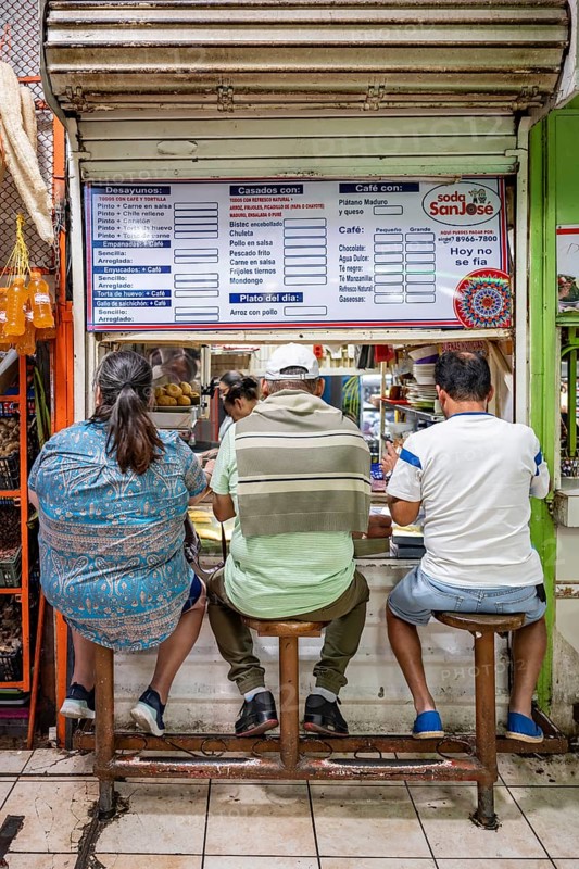 Visitors sitting at a food stall at the counter, Mercado Central de San José, San José, Costa Rica, Central America