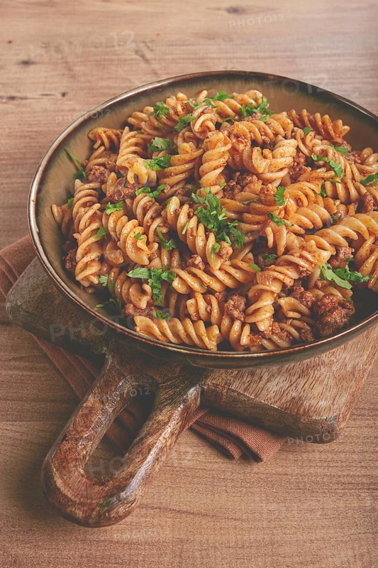 Pasta in the navy, pasta with minced meat, plate on a wooden table, homemade, fusilli pasta, without people