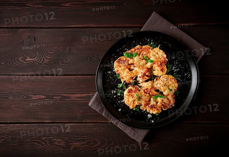 Steak, cauliflower, with cheese, spices, homemade, on a wooden table, dark background, close-up, top view, selective focus, no people
