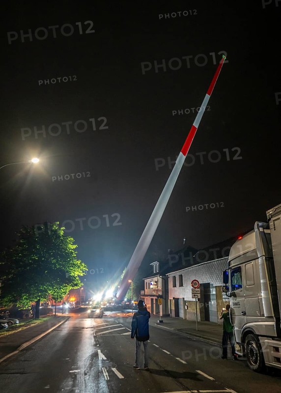 Transport of a 68 metre long, 22 tonne blade of a wind turbine, here in Breckerfeld, with a self-propelled Blade-Lifter vehicle, over a 40 km long route, over 2 nights, in the Bergisches Land, through towns, villages, over country roads, narrow through roads, to the construction site of the wind turbine near Hagen, North Rhine-Westphalia, Germany, Europe