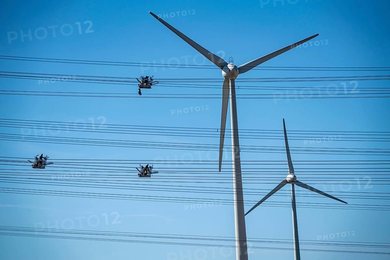 Construction of a new line route, 380 KV extra-high voltage line between Osterath and Gohr, near Neuss, fitters in cable trolleys, on the conductor cables, installing field spacers at great heights, wind power station, North Rhine-Westphalia, Germany, Europe