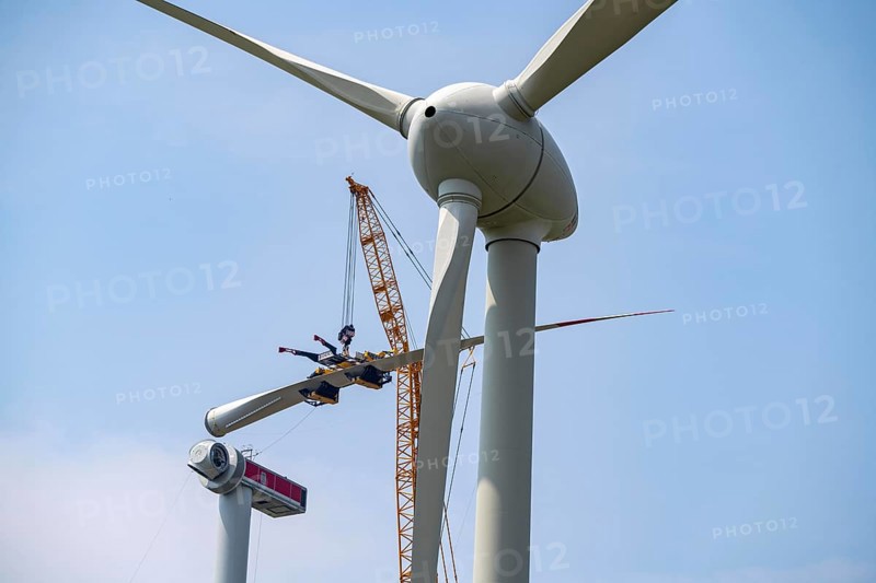 Erection of an Enercon E-160 wind turbine, rear, assembly of the first blade, 4 turbines with a total output of 22 megawatts replace 9 older wind turbines from the manufacturer Enercon (E-58 model series), front, they were in operation for over two decades, Lower Rhine, North Rhine-Westphalia, Germany, Europe