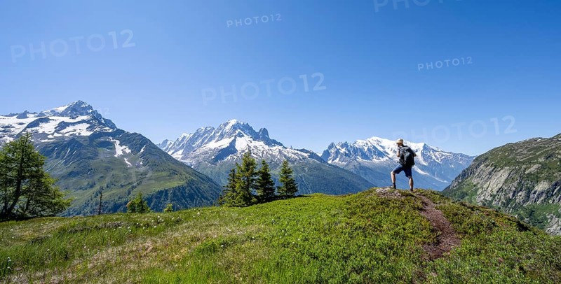 Mountaineer in front of a mountain panorama with glaciated mountain peaks, Aiguille Verte with Aiguille du Midi and Mont Blanc, hike to Aiguillette des Posettes, Chamonix, Haute-Savoie, France, Europe