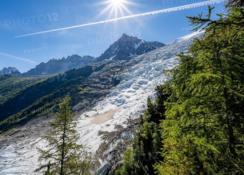 View of glacier Glacier des Bossons with sun star, behind summit of Aiguille du Midi, Chamonix, Haute-Savoie, France, Europe
