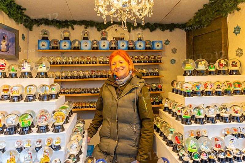Saleswoman in a stand for snow globes at the Christmas market at St Stephen's Cathedral, Stephans-Platz, Vienna, Austria, Europe