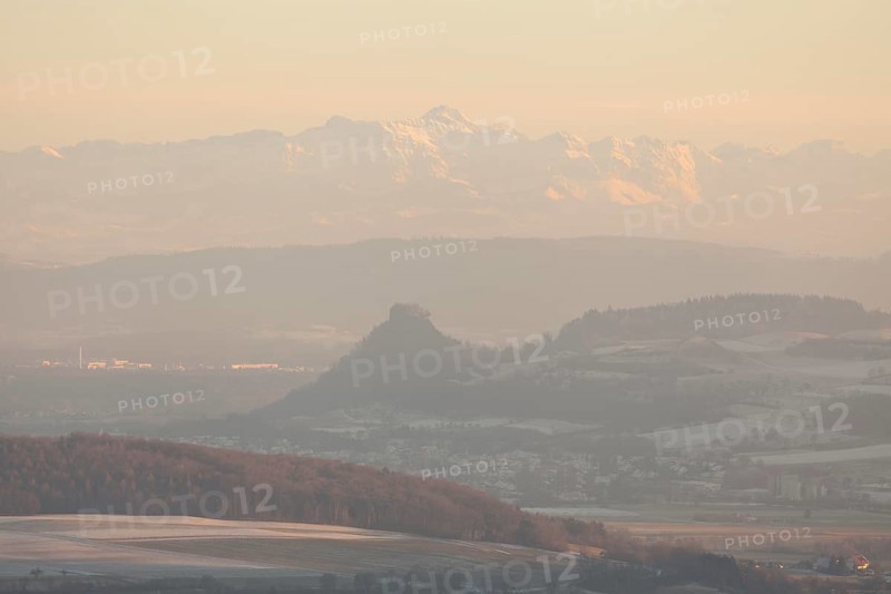 Hegaublick in winter and sunset. Hohenkrähen castle ruins with the Alps and the Säntis